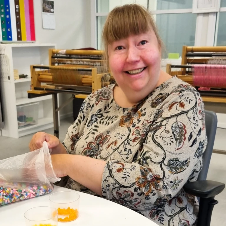 En kvinna ler och tittar in i kameran.