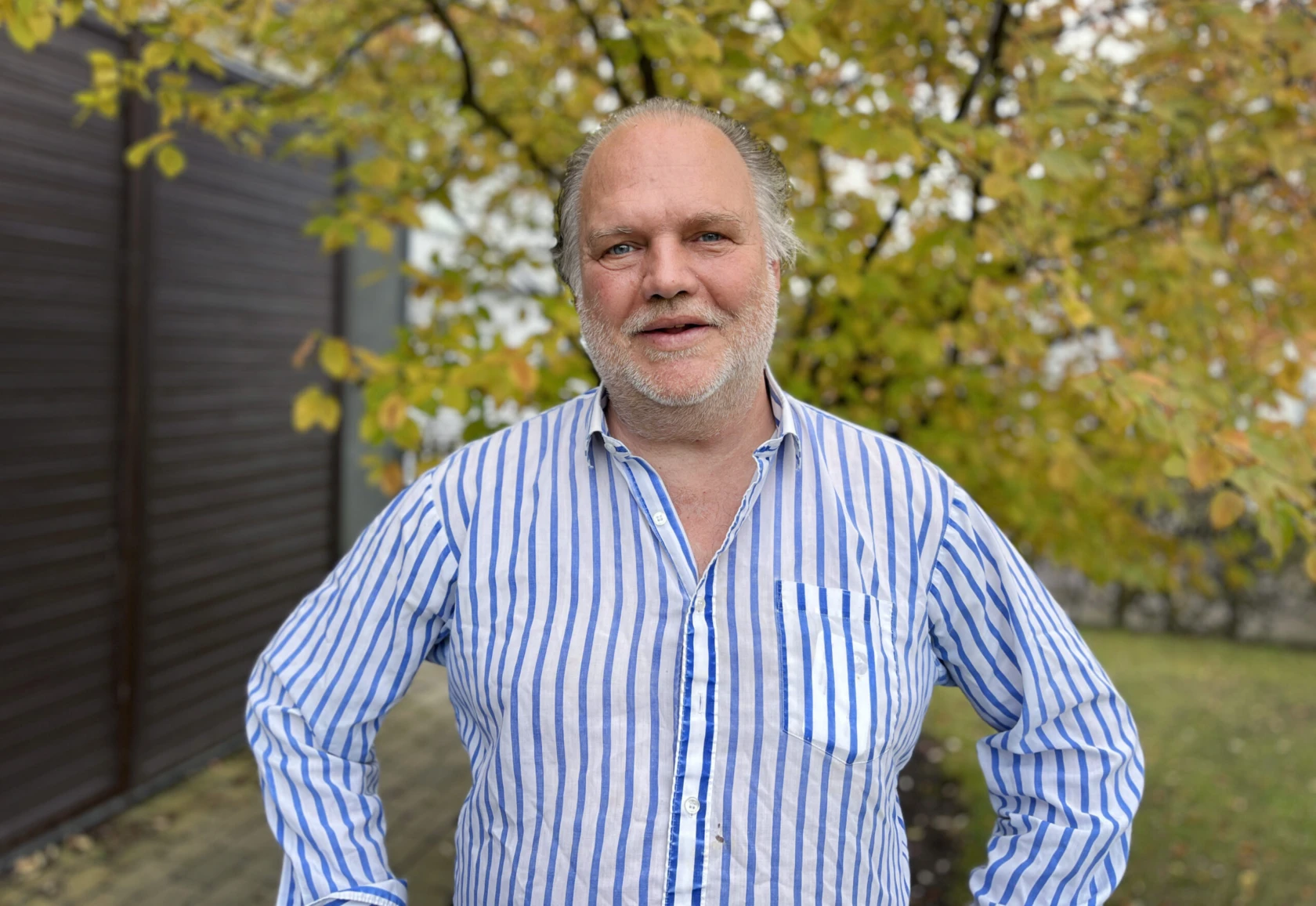 En man tittar in i kameran och ler.