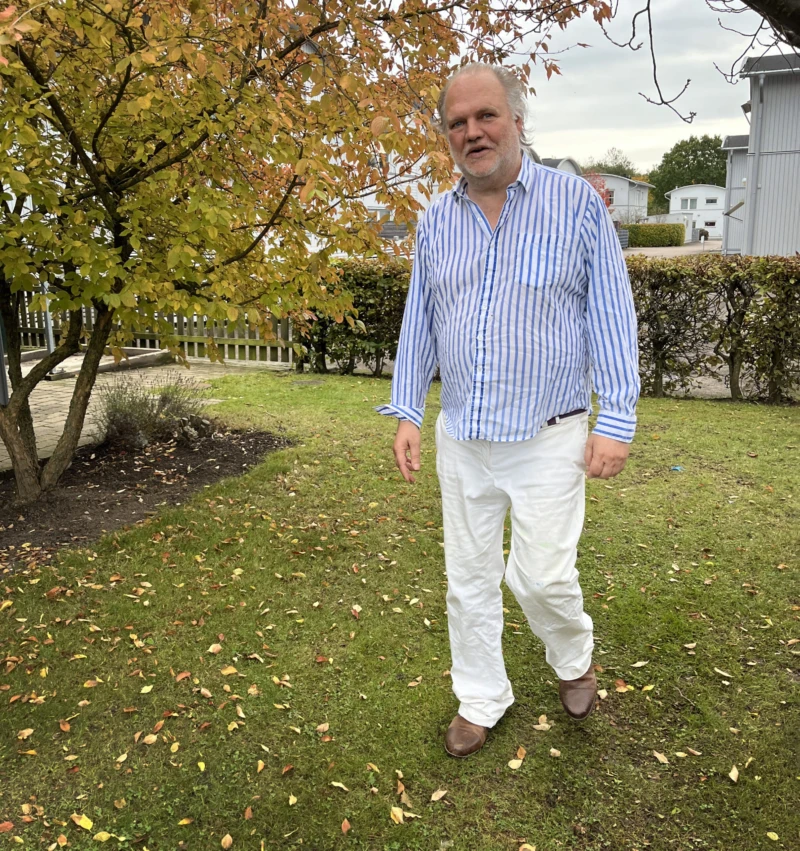 En man som promenerar i en trädgård.