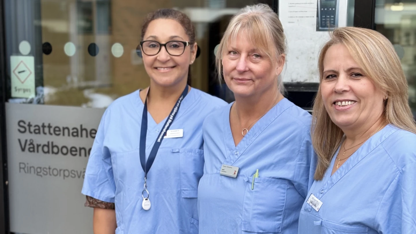 Tre kvinnor leendes in i kameran