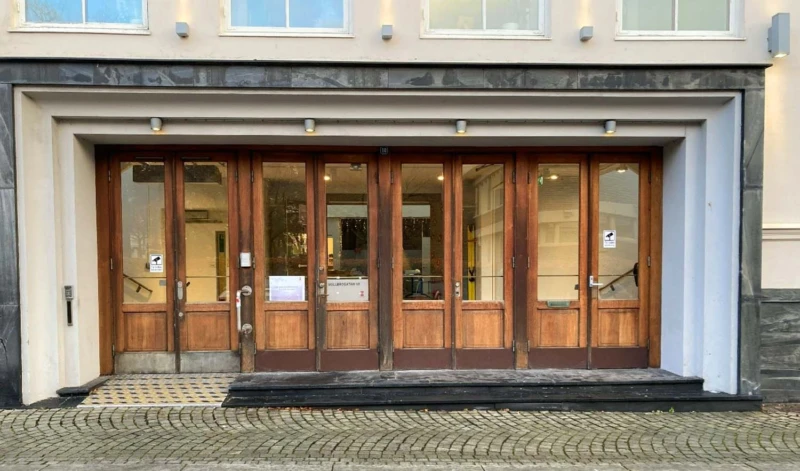 Bild tagen rakt framifrån på en entré med flera trädörrar.