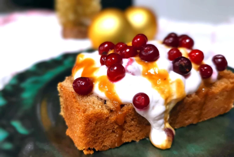 En skiva mjuk kaka dekorerad med kvarg och lingon.