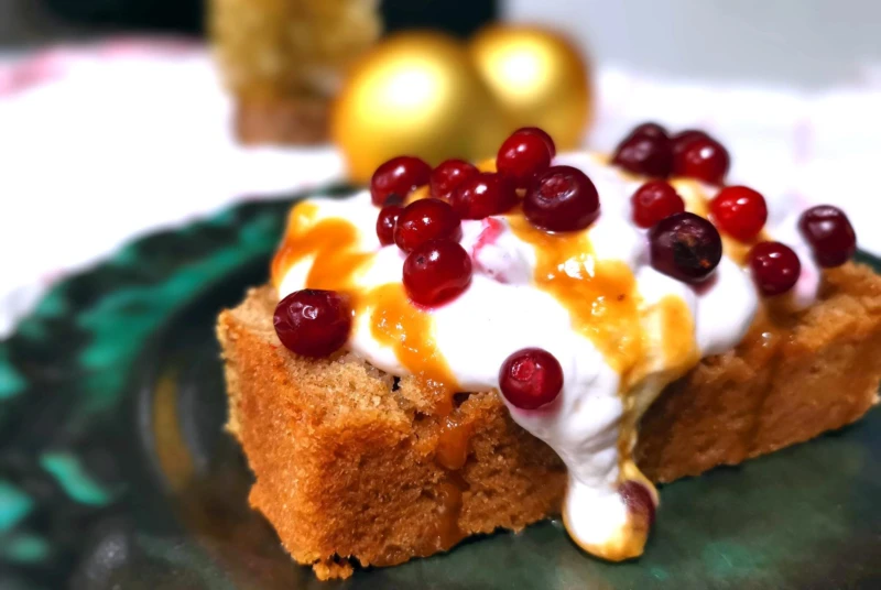 En skiva mjuk kaka dekorerad med kvarg och lingon.