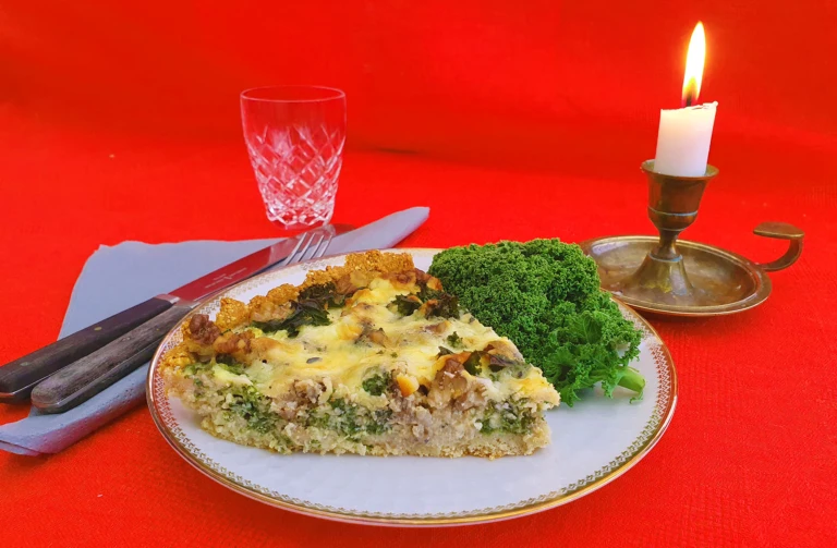 En portion med en bit matpaj med grönkål vid sidan.