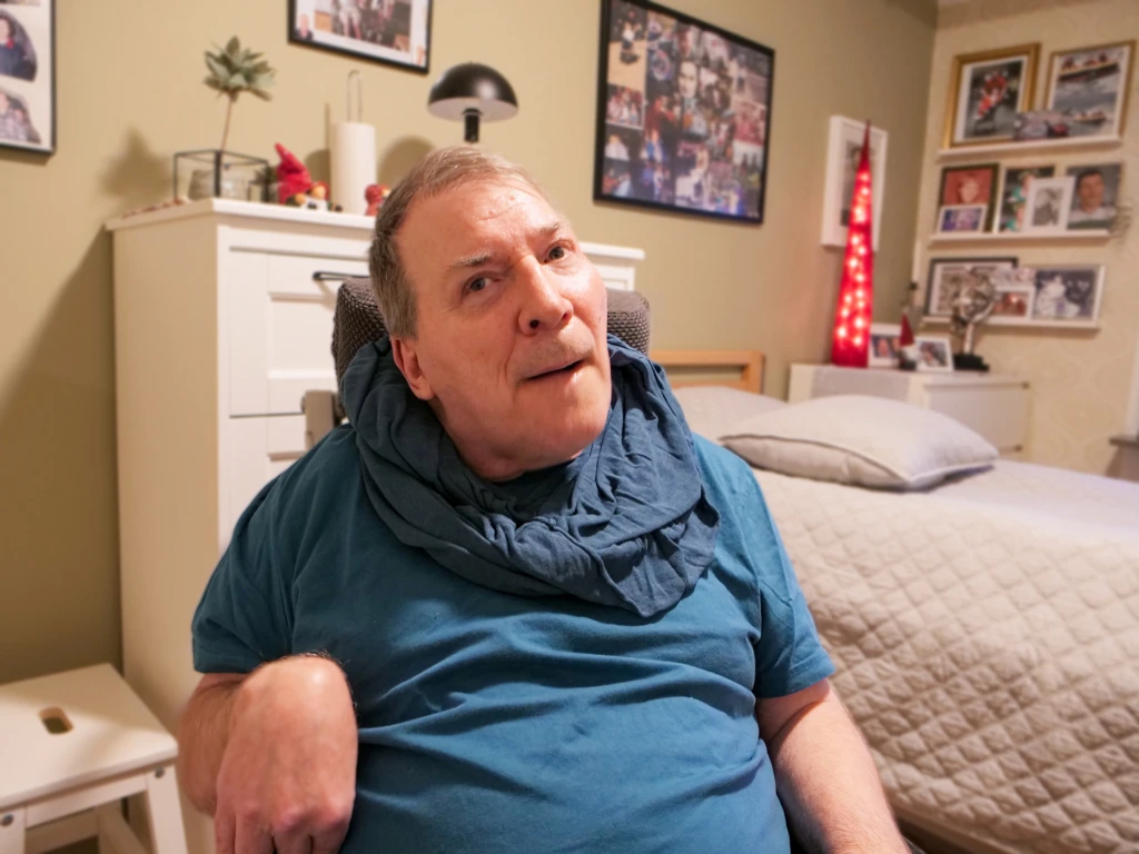 En person ler och tittar in i kameran.