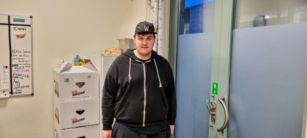 En ung kille med keps tittar in i kameran.