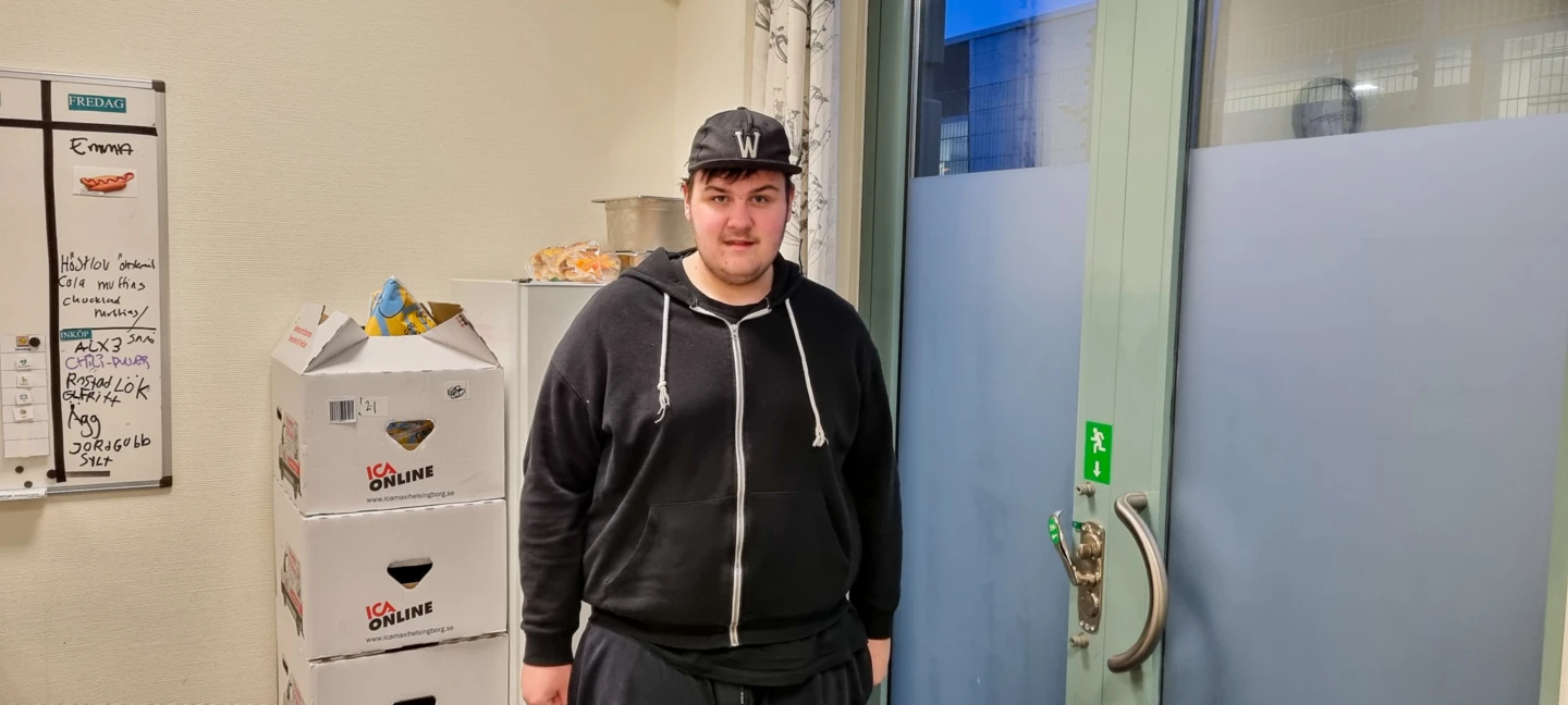 En ung kille med keps tittar in i kameran.