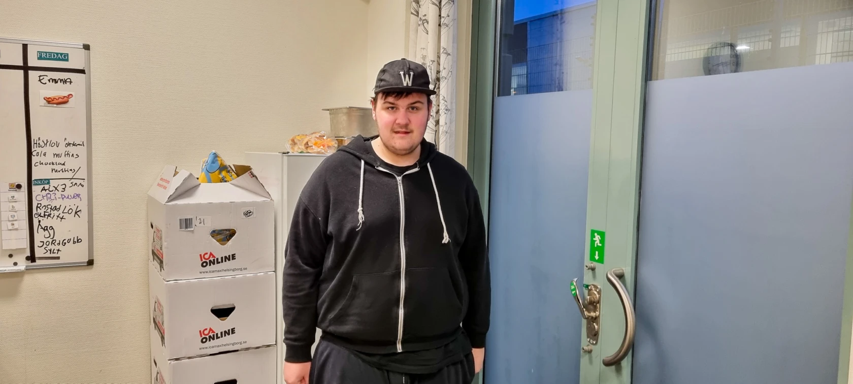 En ung kille med keps tittar in i kameran.