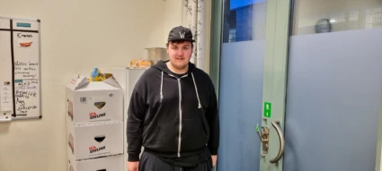 En ung kille med keps tittar in i kameran.