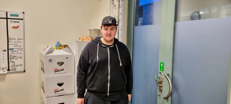 En ung kille med keps tittar in i kameran.