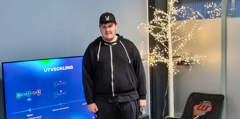 En ung kille med keps tittar in i kameran.