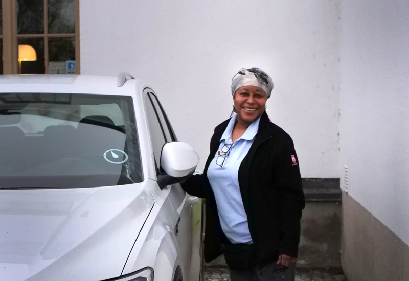 Kvinna som står bredvid en bil.