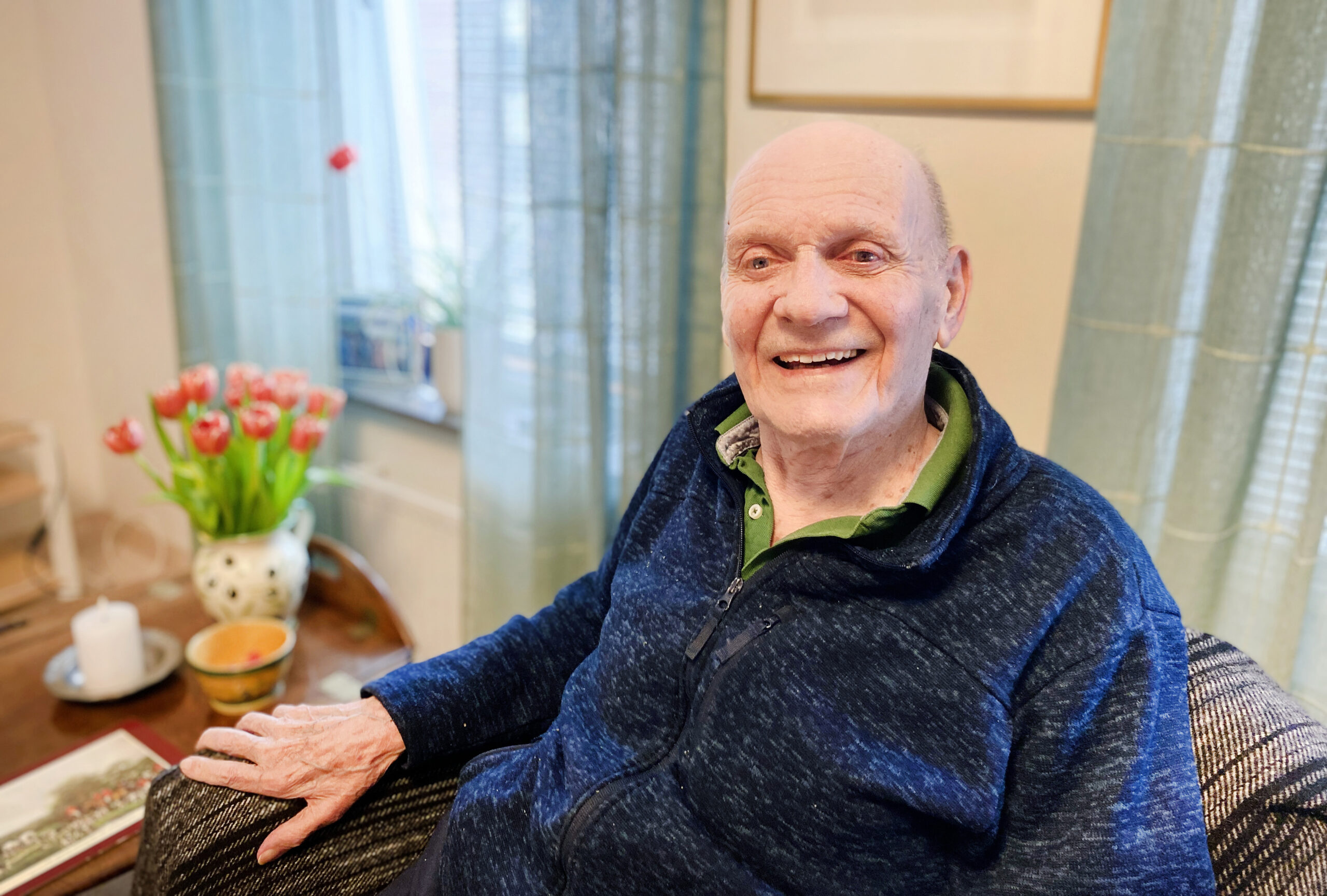 En man tittar in i kameran och ler.