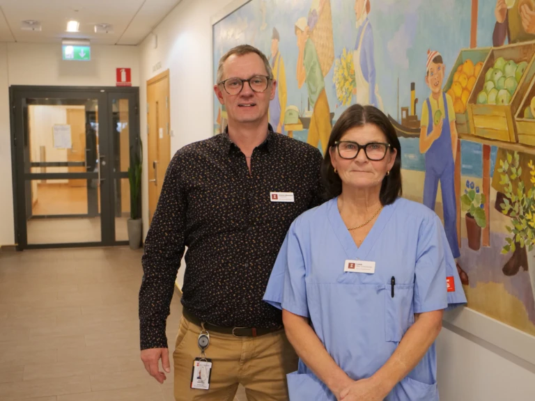 Två personer som tittar in i kameran