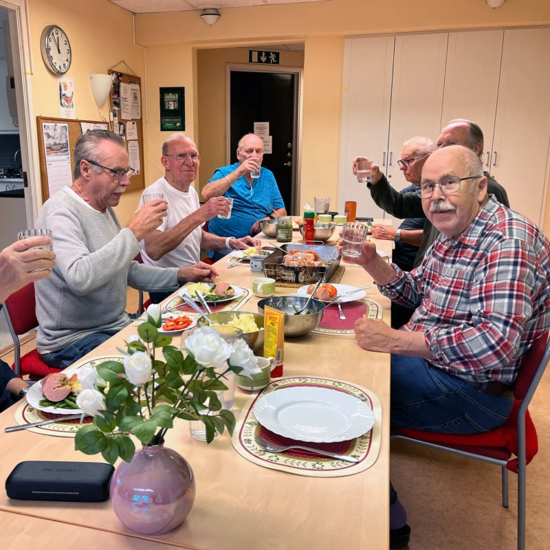 Flera människor är glada och äter runt ett bord