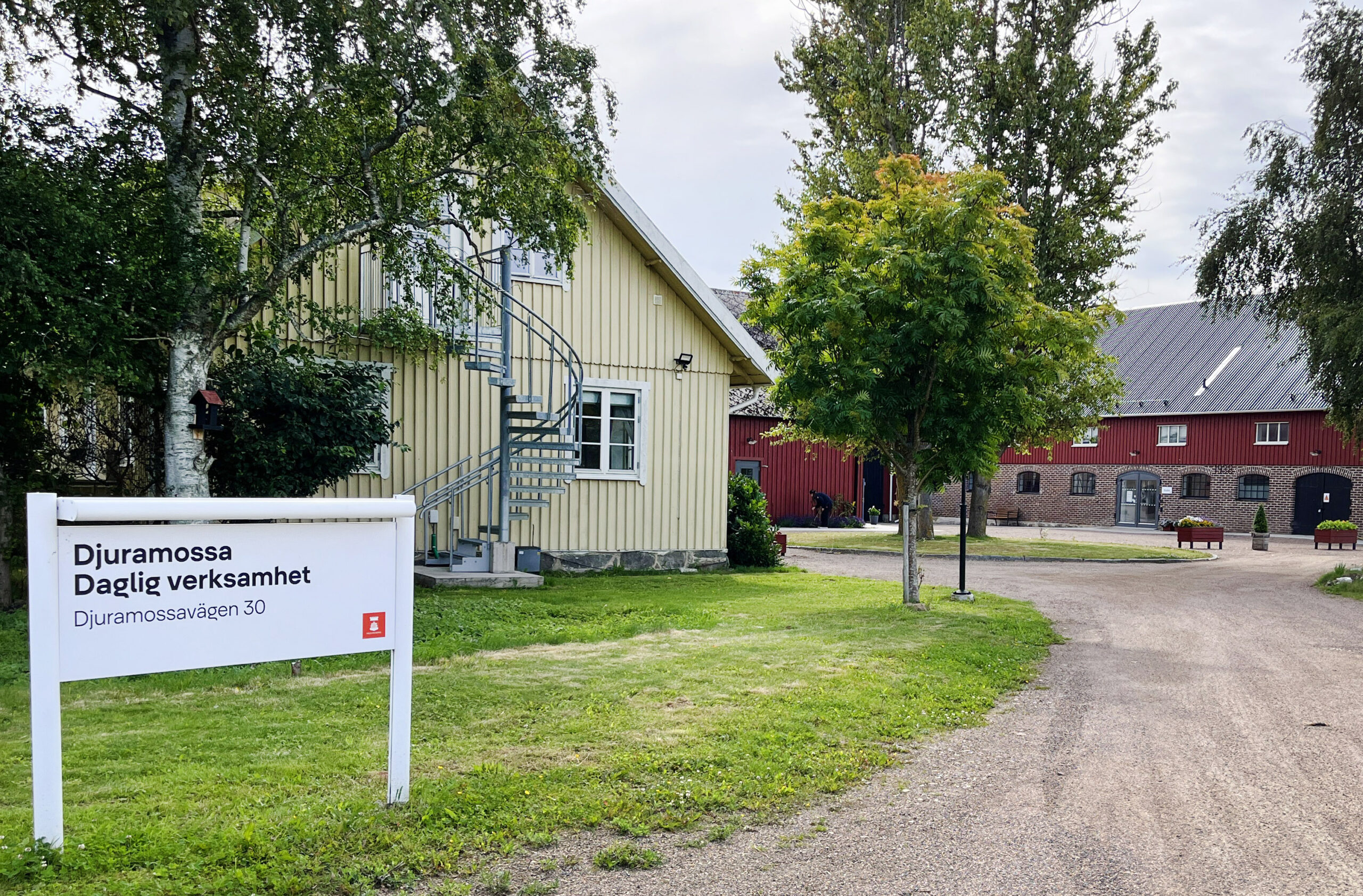 Bild på en gård med en skylt med texten Djuramossa Daglig verksamhet.