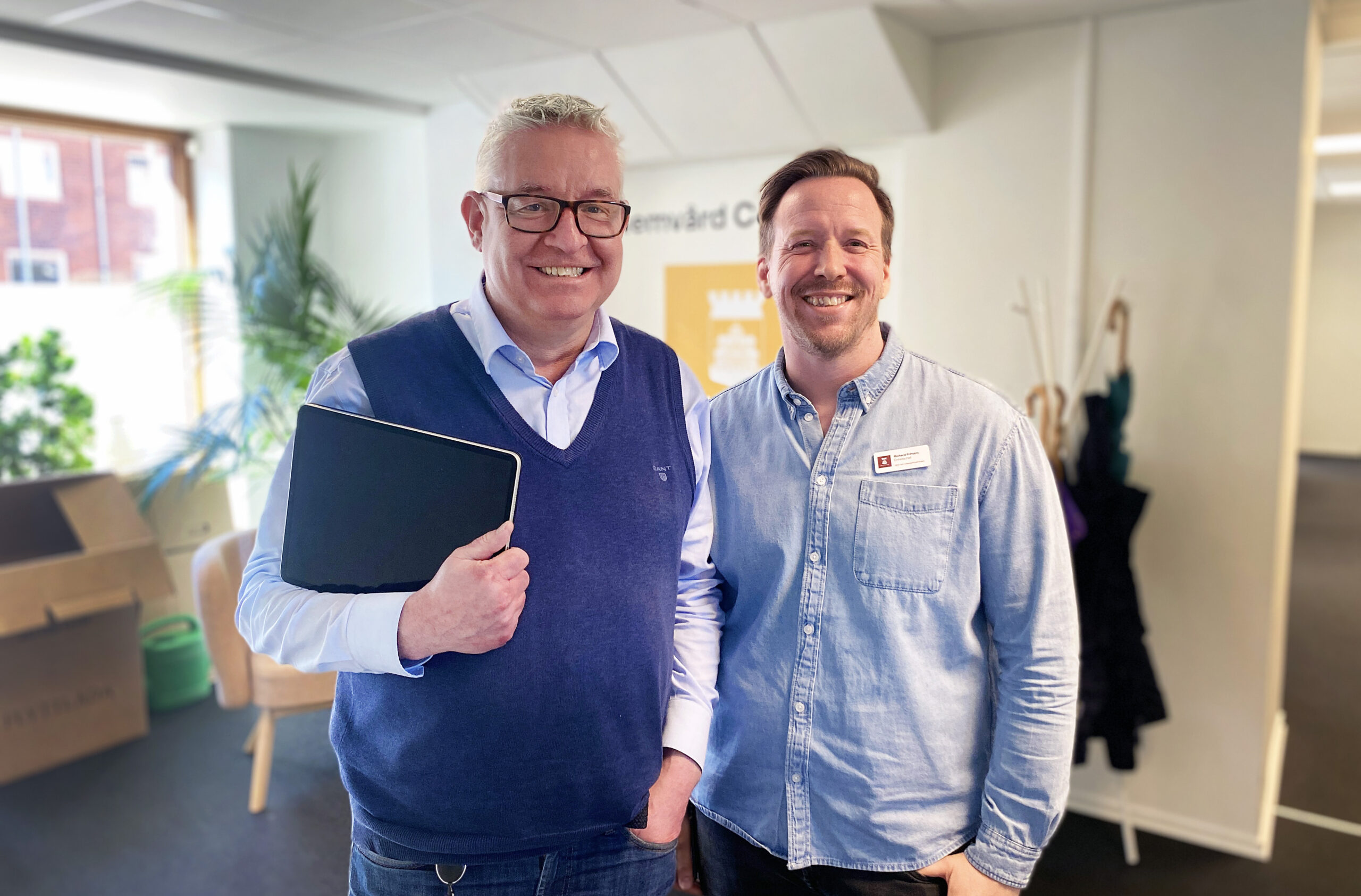 Två män tittar in i kameran och ler.