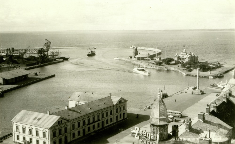 : Svartvitt vykort. Utsikt över Helsingborgs hamn, Parapeten och Öresund. I förgrunden Tullhuset och en Zoégas reklamskylt. Vid hamninloppet syns två fartyg. På andra sidan sundet skymtar den danska kusten.