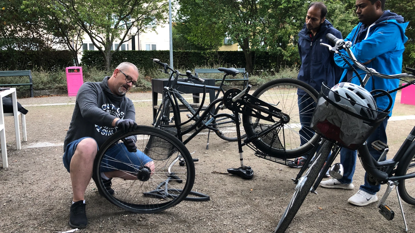 Krister Lund tillsammans med deltagare i cykelreparationsworkshop på Furutorpsplatsen i Helsingborg.