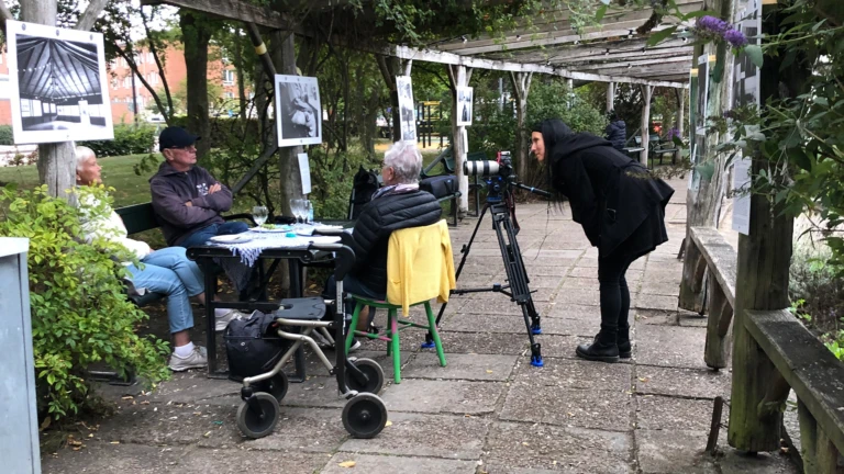 Sarah Perfekt fotograferar en grupp människor som fikar på Furutorpsplatsen.