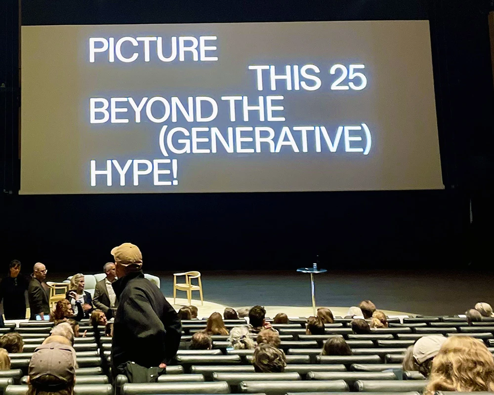 Konferenssal med publik som anländer.