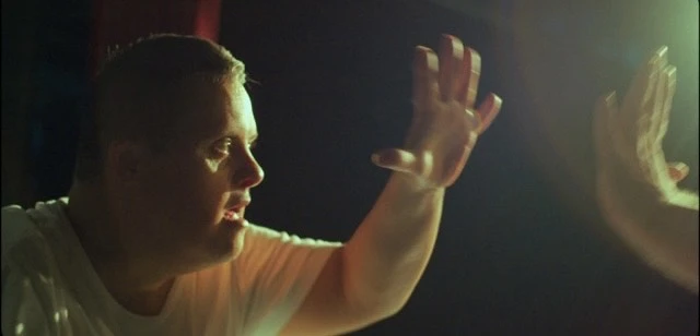 En man håller upp sin hand och möter en annan hand framför sig.