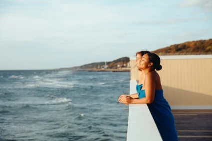 två kvinnor på pålsjö kallbadshus blickar ut mot havet