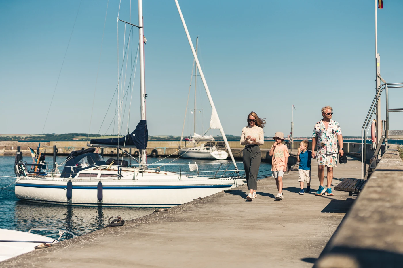 En familj går på piren i Bäckvikens hamn