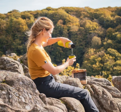 En kvinna häller upp kaffe ur en termos