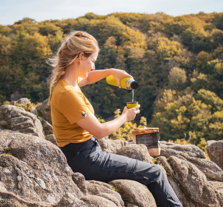 En kvinna häller upp kaffe ur en termos