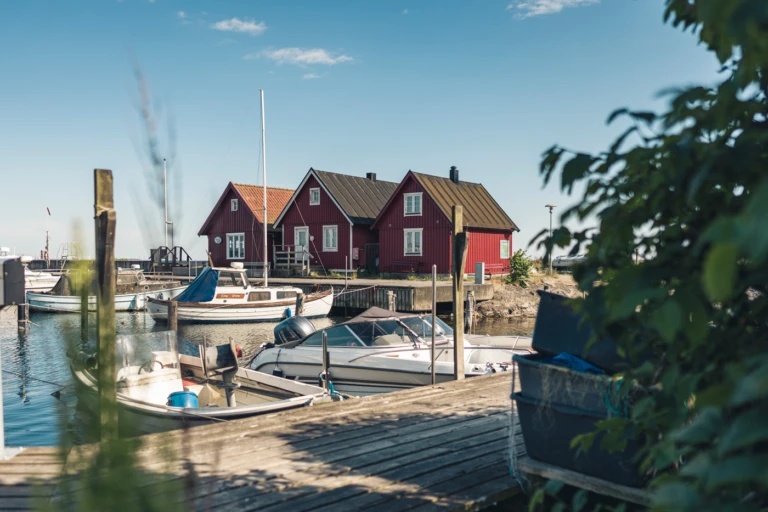 Tre röda fiskehoddor i Bäckvikens hamn