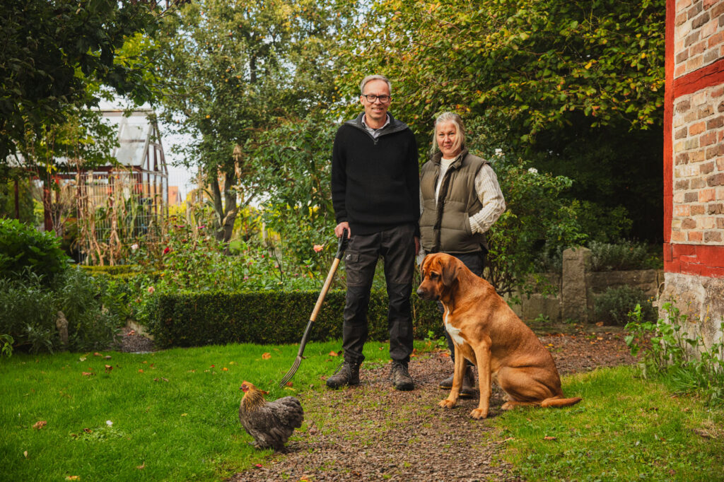 Anders och Linda, ägare av Aplagården. På gården med deras hund och en höna.