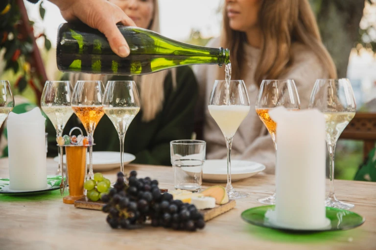 vinprovning på aplgården. Vin hälls upp i ett glas