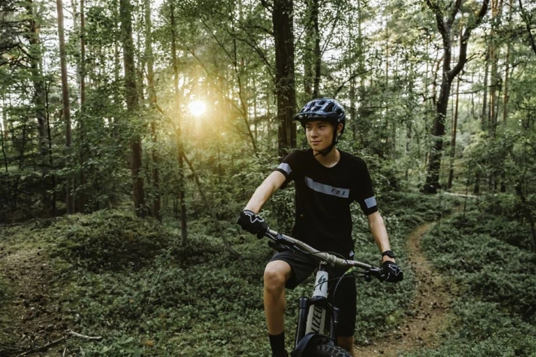 Kille på mountainbike i en skog