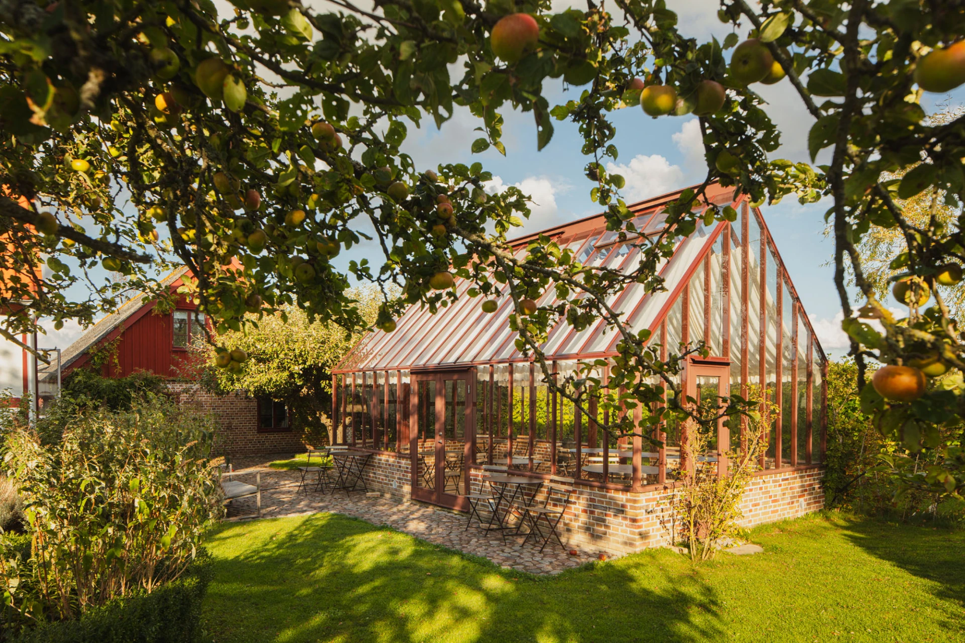 Orangeri i en lummig trädgård