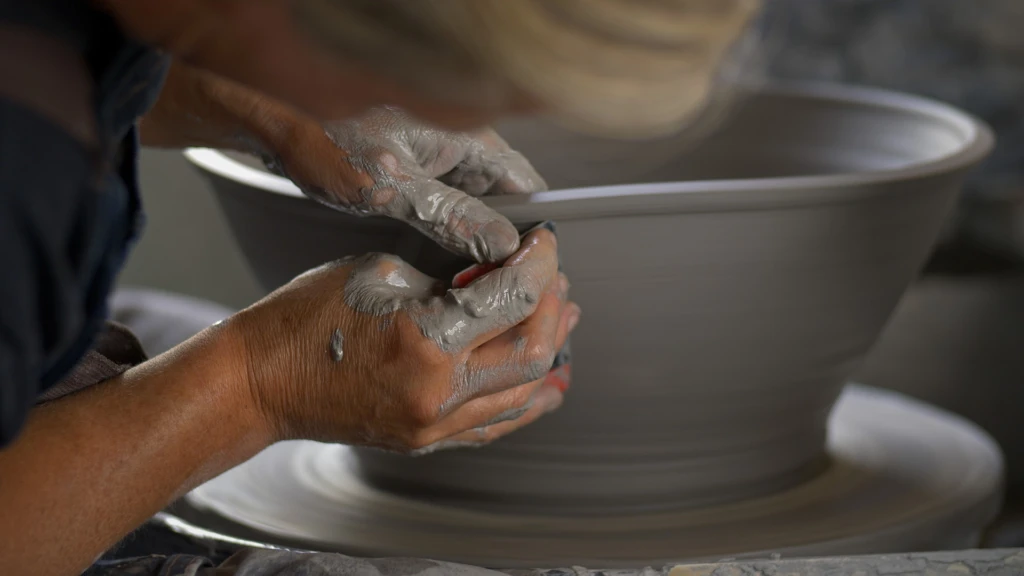 en person drejar en skål, Närbild på hand, skål och drejplatta