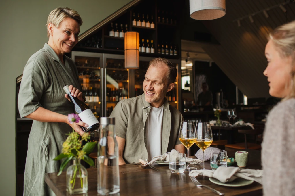 restaurang Flora, servitris erbjuder vin