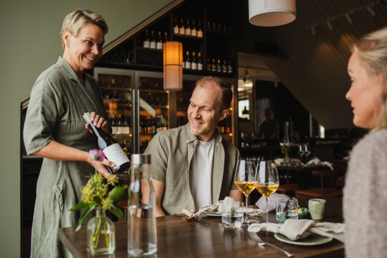 restaurang Flora, servitris erbjuder vin